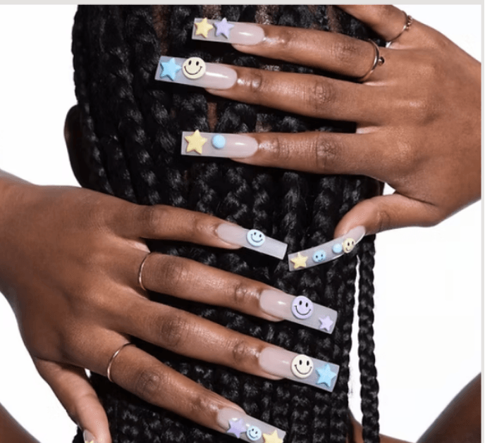 Manicured nails with pastel star and smiley-face charms